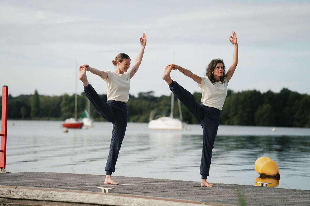 deux femmes dans la posture de yoga du gros orteil tenu 