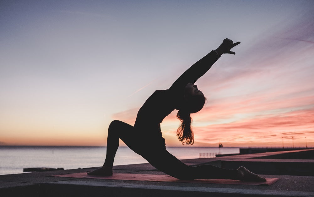 femme pratiquant le yoga au crépuscule