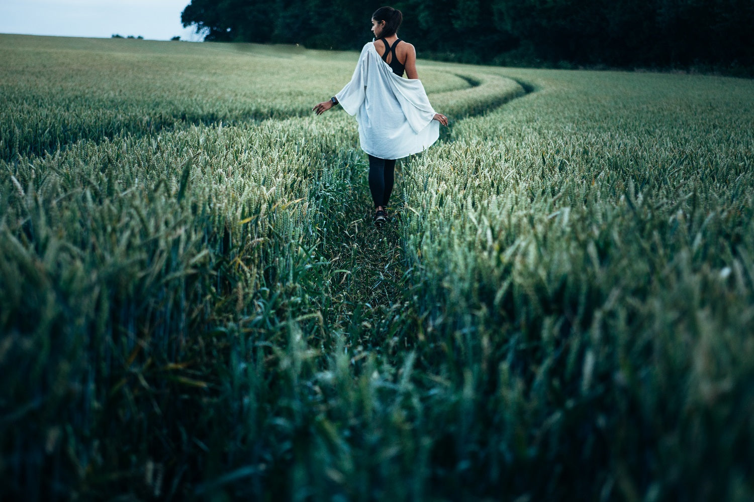 jeune femme qui se promène dans un champ de blé mûr
