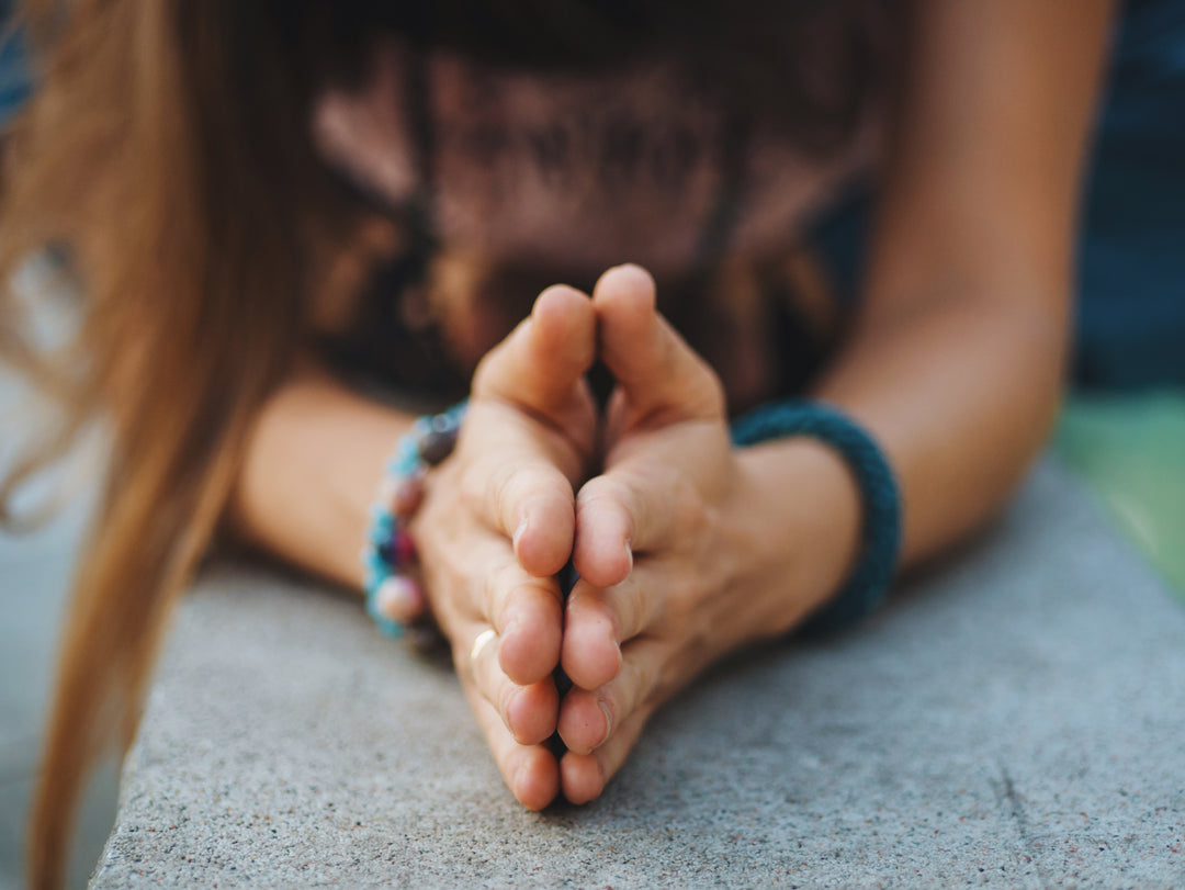 mains en prière d'une jeune femme faisant du yoga