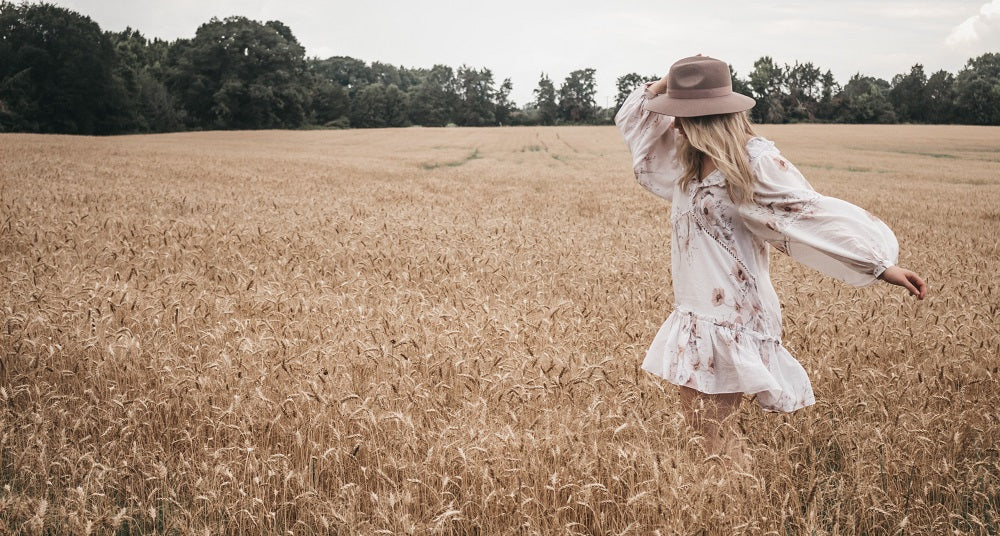 jeune femme en robe d'été qui court dans un champ