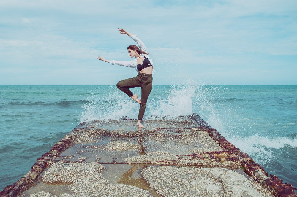 jeune femme dansant sur un ponton au bord de la mer