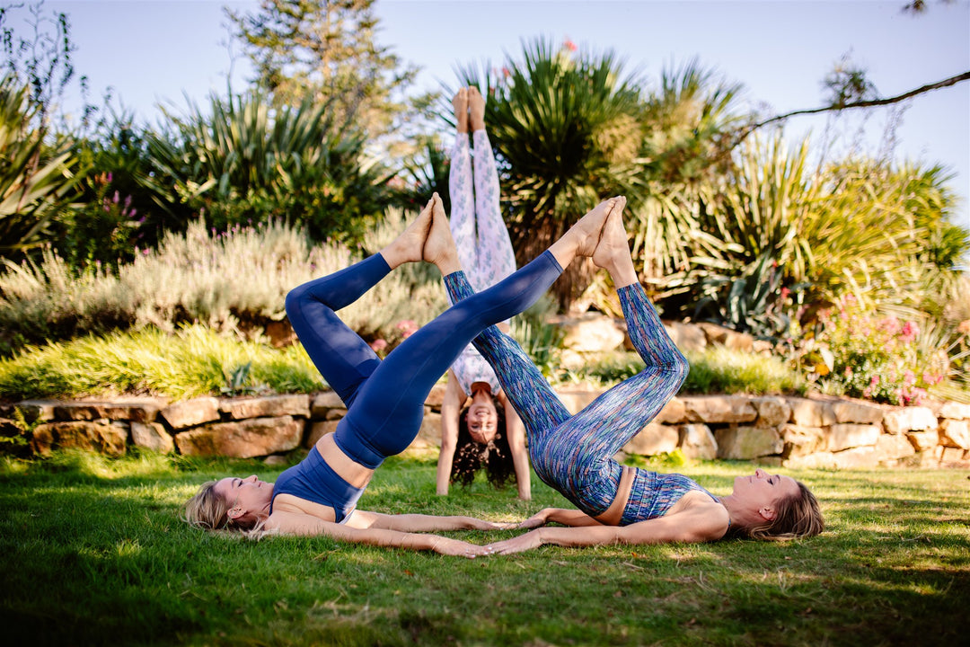 trois jeunes femmes en train de faire du yoga dans le jardin